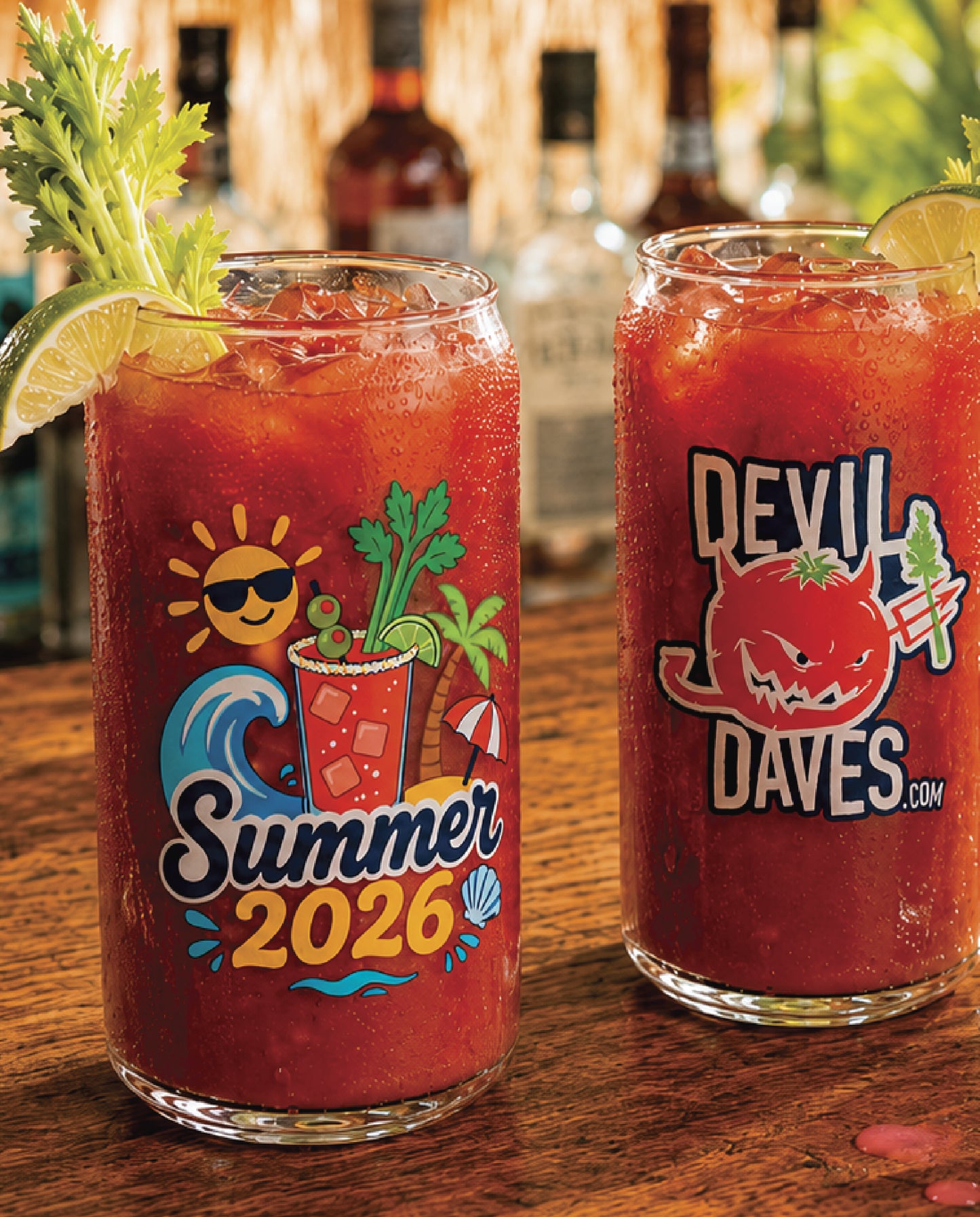 Two bloody mary cocktails in Devil daves summer 2026 can glasses with decorative text and graphics on a wooden surface.