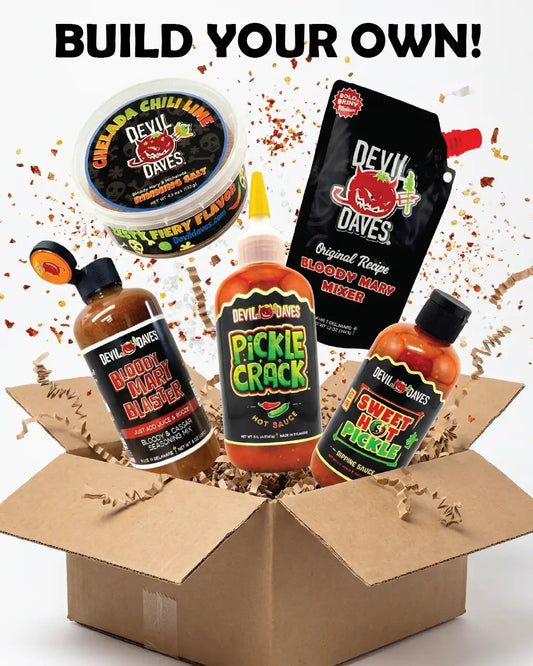 Assorted Devil Daves hot sauce and bloody mary products in an open cardboard box with 'Build Your Own bloody mary bundle' text above.