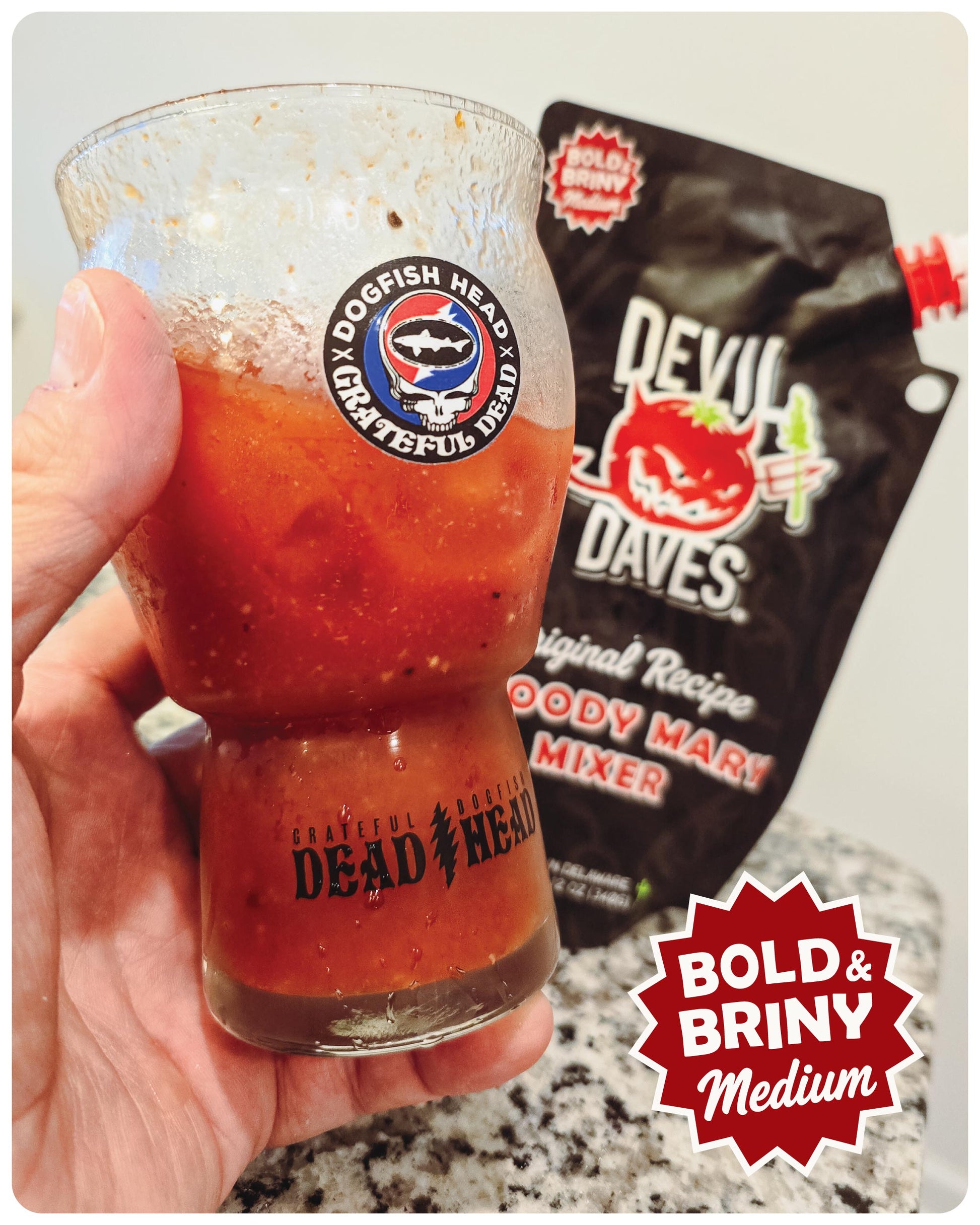 Glass of bloody mary mix in a Dogfish Head glass, next to a bag of Devil Dave's Bloody Mary mixer.